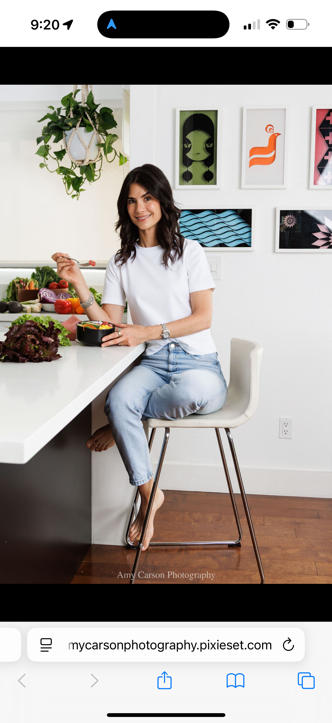 Rosé sonriendo mientras disfruta un bowl de comida en la cocina. Foto de Amy Carson Photography.
